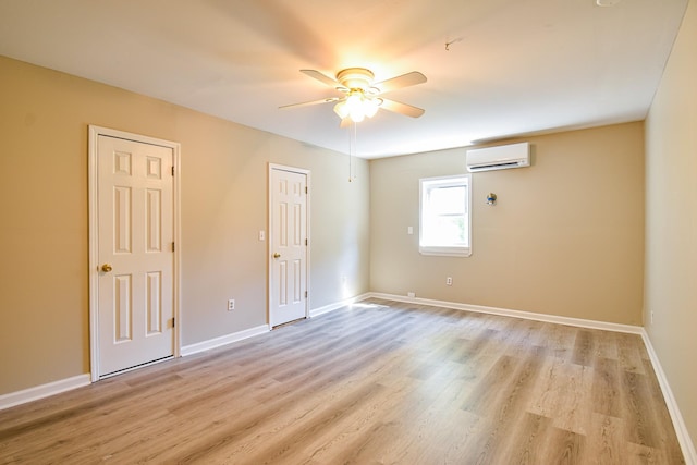 empty room with ceiling fan, light hardwood / wood-style flooring, and a wall mounted AC