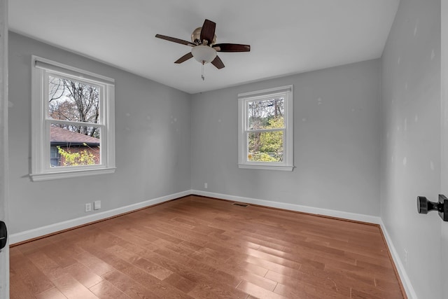 spare room featuring ceiling fan, a wealth of natural light, and light hardwood / wood-style flooring