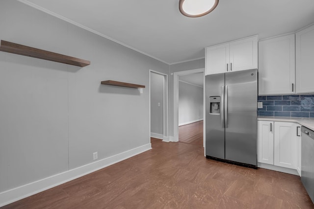 kitchen featuring white cabinets, backsplash, ornamental molding, and stainless steel appliances