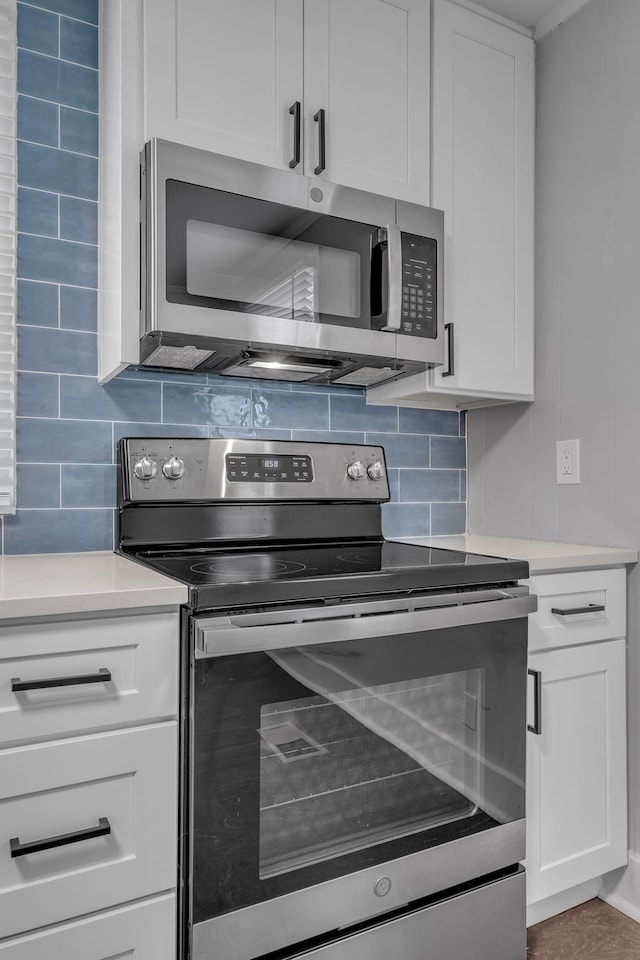 kitchen with white cabinets, stainless steel appliances, and tasteful backsplash