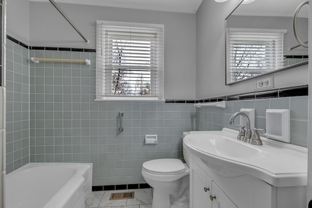 full bathroom featuring vanity,  shower combination, toilet, and tile walls