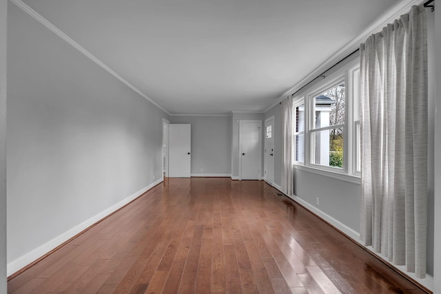 empty room featuring wood-type flooring and ornamental molding