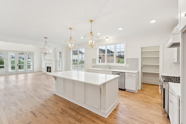 kitchen with a kitchen breakfast bar, white cabinetry, dishwasher, and a kitchen island