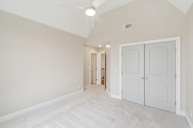 unfurnished bedroom with ceiling fan, light colored carpet, high vaulted ceiling, and a closet