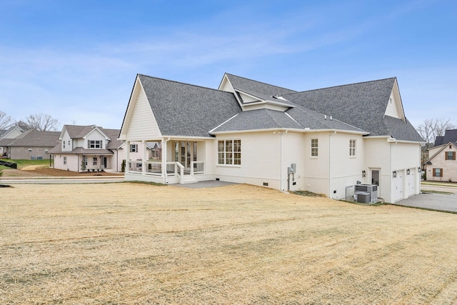 rear view of house with central AC unit, a porch, and a garage