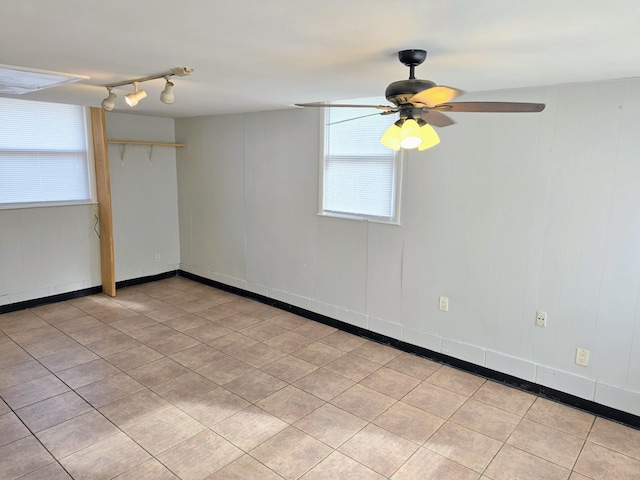 empty room with ceiling fan, rail lighting, and light tile patterned floors