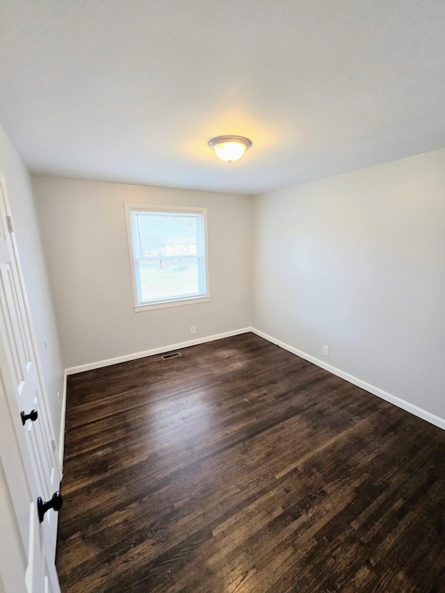 unfurnished room featuring dark hardwood / wood-style flooring