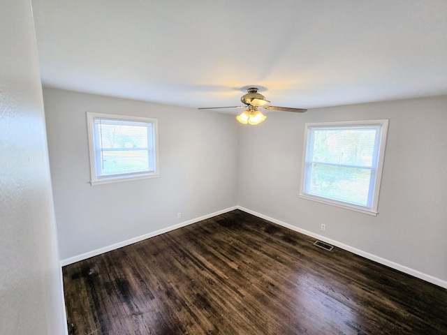 spare room with ceiling fan, plenty of natural light, and dark hardwood / wood-style floors