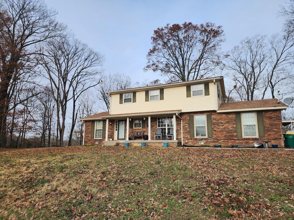 view of front of house with covered porch and a front yard