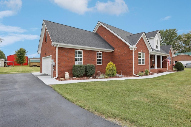 view of side of property with a lawn, covered porch, and a garage