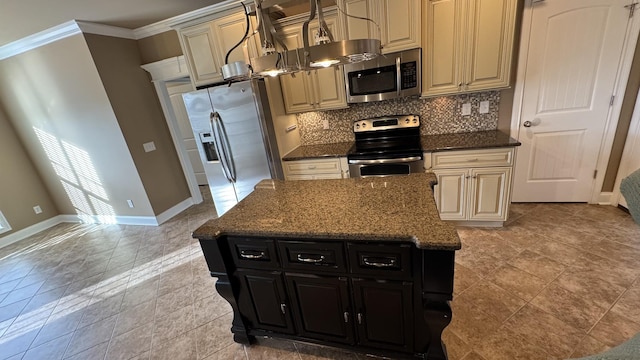 kitchen with backsplash, dark stone counters, crown molding, appliances with stainless steel finishes, and a kitchen island