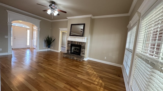 unfurnished living room with crown molding, a fireplace, ceiling fan, and dark hardwood / wood-style floors