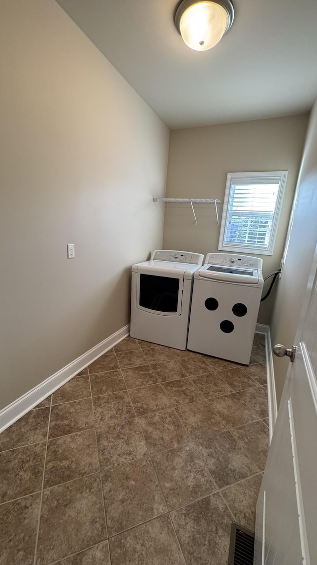 washroom with washer and dryer and dark tile patterned floors