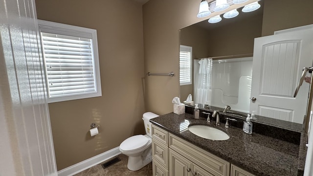 bathroom with tile patterned flooring, vanity, toilet, and walk in shower