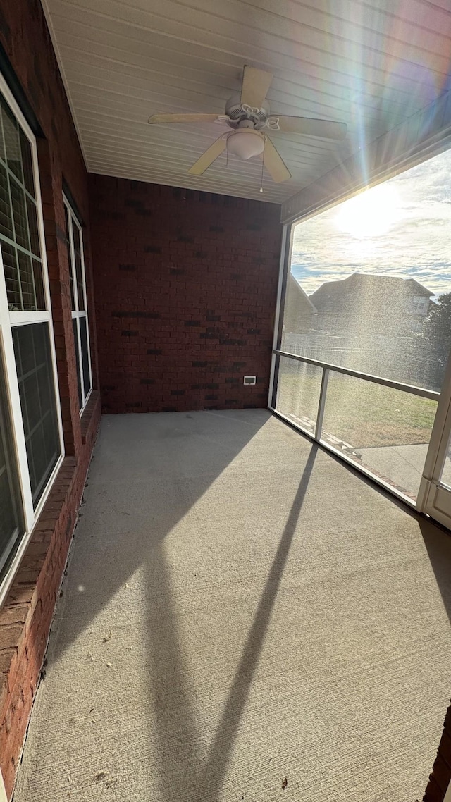 unfurnished sunroom with ceiling fan and a healthy amount of sunlight