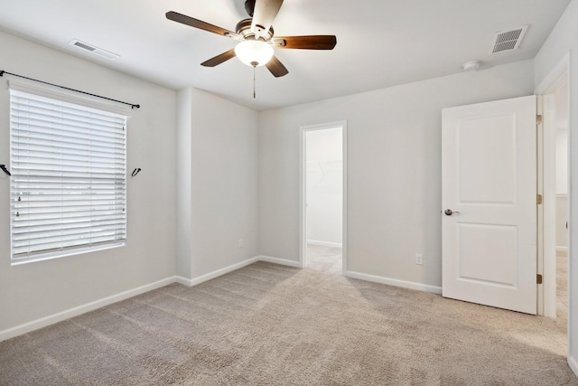 carpeted spare room featuring ceiling fan