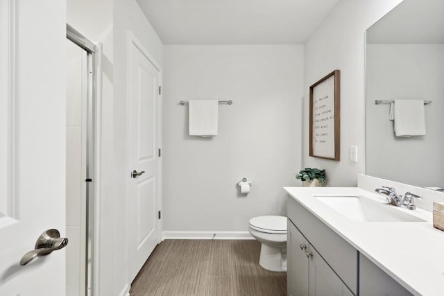 bathroom with vanity, toilet, and wood-type flooring