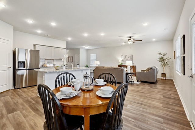 dining room with light wood-type flooring and ceiling fan