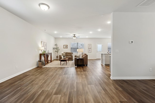 living room featuring ceiling fan and dark wood-type flooring