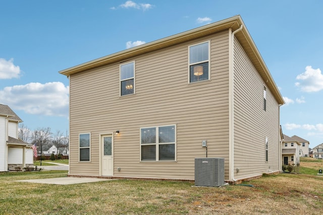 rear view of property featuring a yard and cooling unit