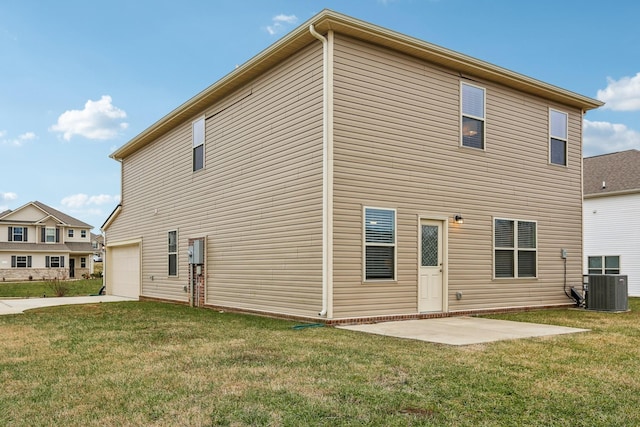 rear view of property featuring a garage, a yard, and central air condition unit