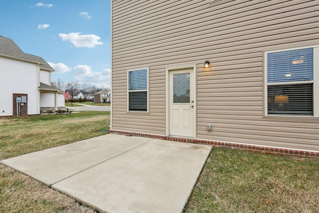 property entrance featuring a lawn and a patio area