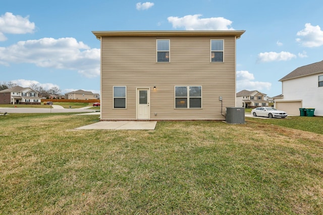 rear view of house with a yard, a patio, and central AC