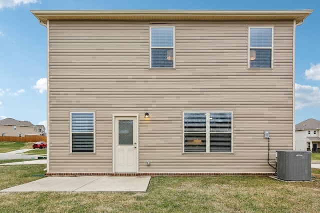 rear view of house with a lawn, a patio area, and central AC unit