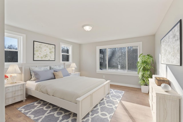 bedroom with multiple windows and light hardwood / wood-style floors