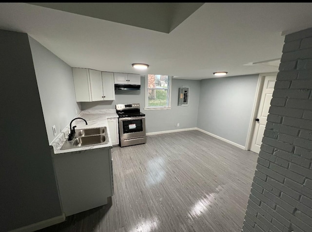 kitchen featuring hardwood / wood-style floors, stainless steel electric range, electric panel, sink, and white cabinetry