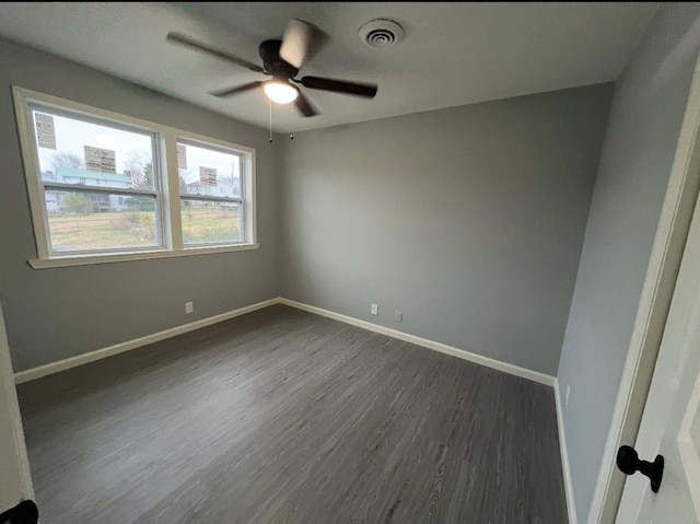 empty room with dark hardwood / wood-style floors and ceiling fan