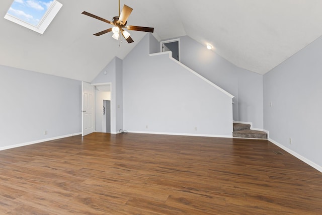 unfurnished living room with ceiling fan, dark wood-type flooring, and vaulted ceiling with skylight