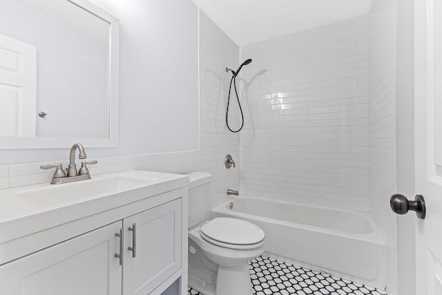 full bathroom with tiled shower / bath, vanity, and toilet