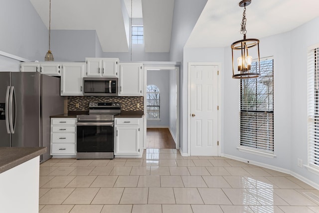 kitchen featuring white cabinetry, hanging light fixtures, appliances with stainless steel finishes, and tasteful backsplash