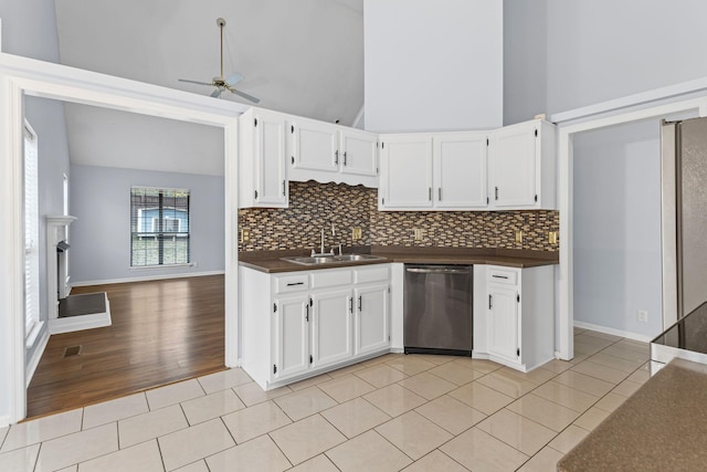 kitchen featuring dishwasher, white cabinets, high vaulted ceiling, and sink