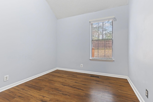 spare room featuring a textured ceiling and hardwood / wood-style flooring