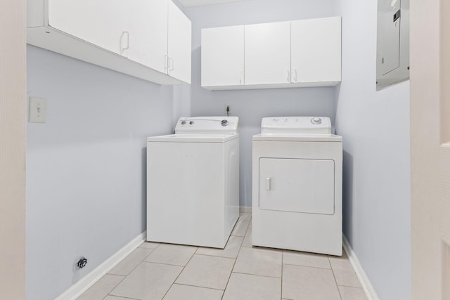 washroom with cabinets, electric panel, light tile patterned flooring, and washing machine and clothes dryer