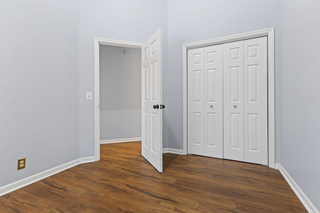 unfurnished bedroom featuring dark hardwood / wood-style floors and a closet