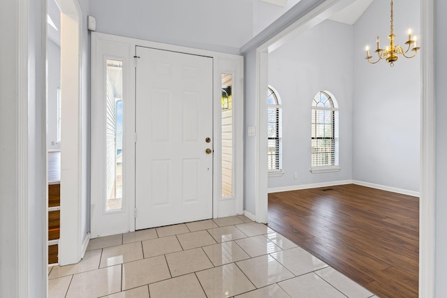 tiled entryway featuring a chandelier