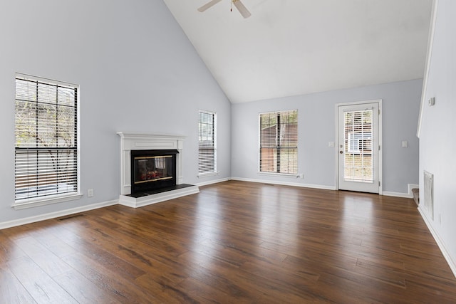 unfurnished living room with high vaulted ceiling, ceiling fan, and dark wood-type flooring