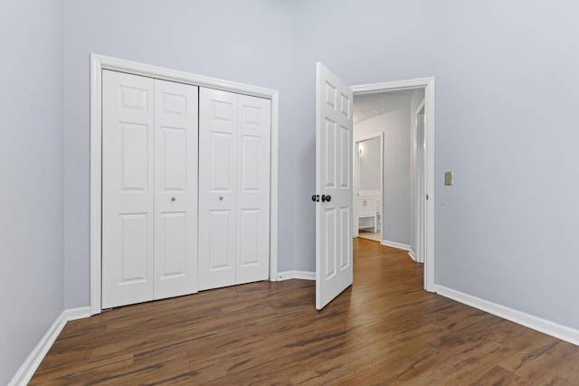 unfurnished bedroom featuring dark hardwood / wood-style floors and a closet