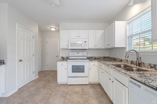 kitchen featuring white cabinetry, light stone counters, white appliances, and sink