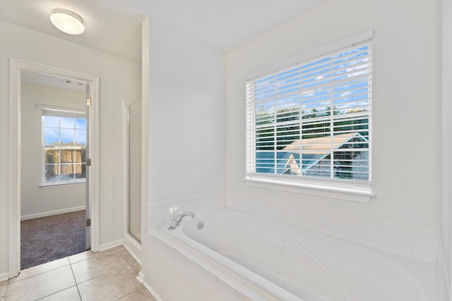 bathroom featuring a wealth of natural light, tile patterned flooring, and independent shower and bath