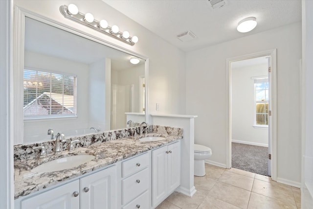 bathroom featuring tile patterned floors, vanity, a textured ceiling, and toilet