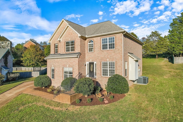 view of front of home featuring central AC unit and a front yard