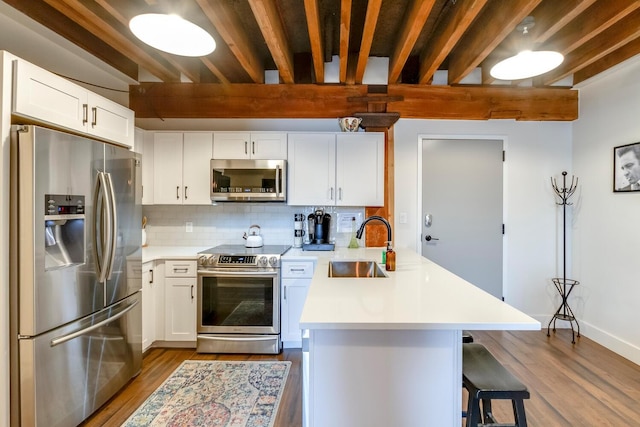 kitchen with sink, beamed ceiling, decorative backsplash, white cabinets, and appliances with stainless steel finishes