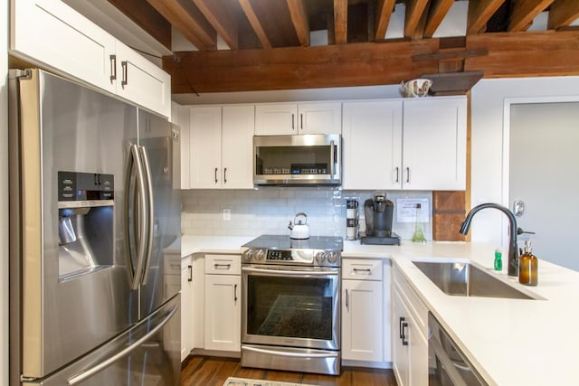 kitchen featuring sink, decorative backsplash, dark hardwood / wood-style floors, appliances with stainless steel finishes, and white cabinetry