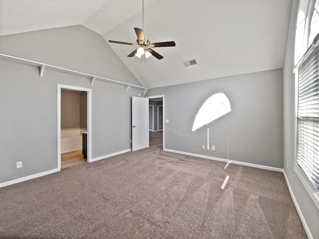 unfurnished bedroom featuring carpet flooring, ceiling fan, lofted ceiling, and ensuite bath