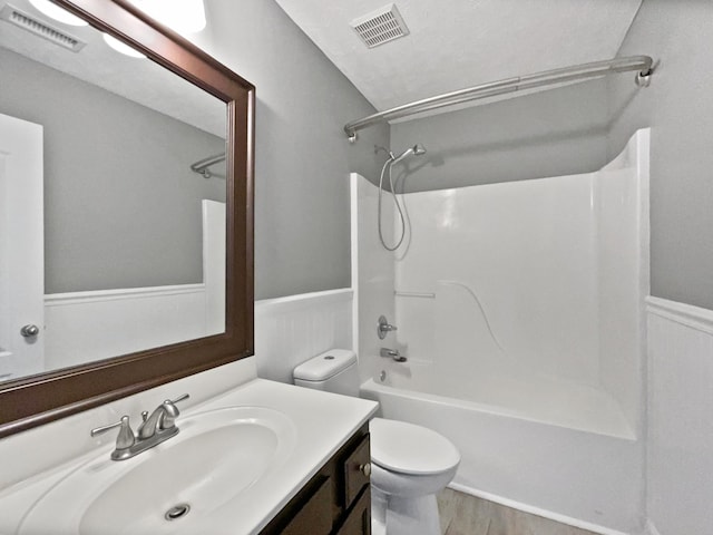 full bathroom with hardwood / wood-style floors, vanity, toilet, and tub / shower combination