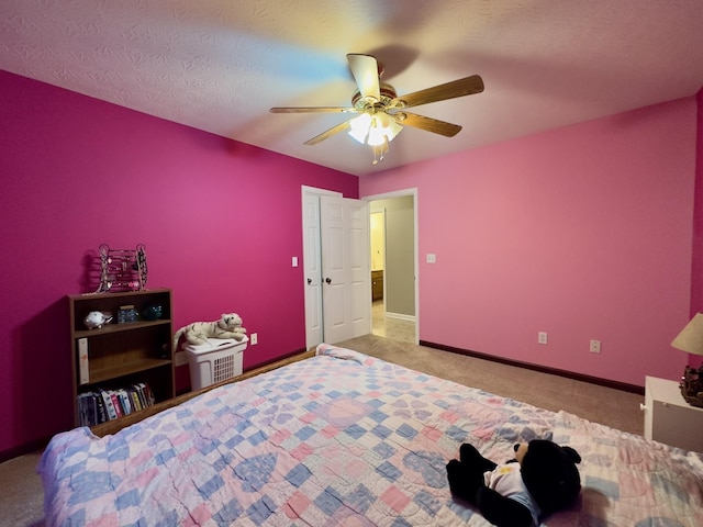 carpeted bedroom with ceiling fan and a textured ceiling